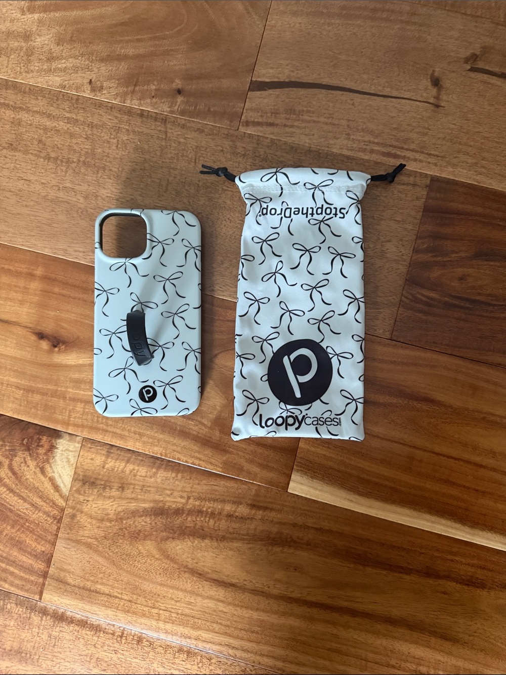 Loopy Case White Phone Case with Black Bow Pattern and Black Hand Strap